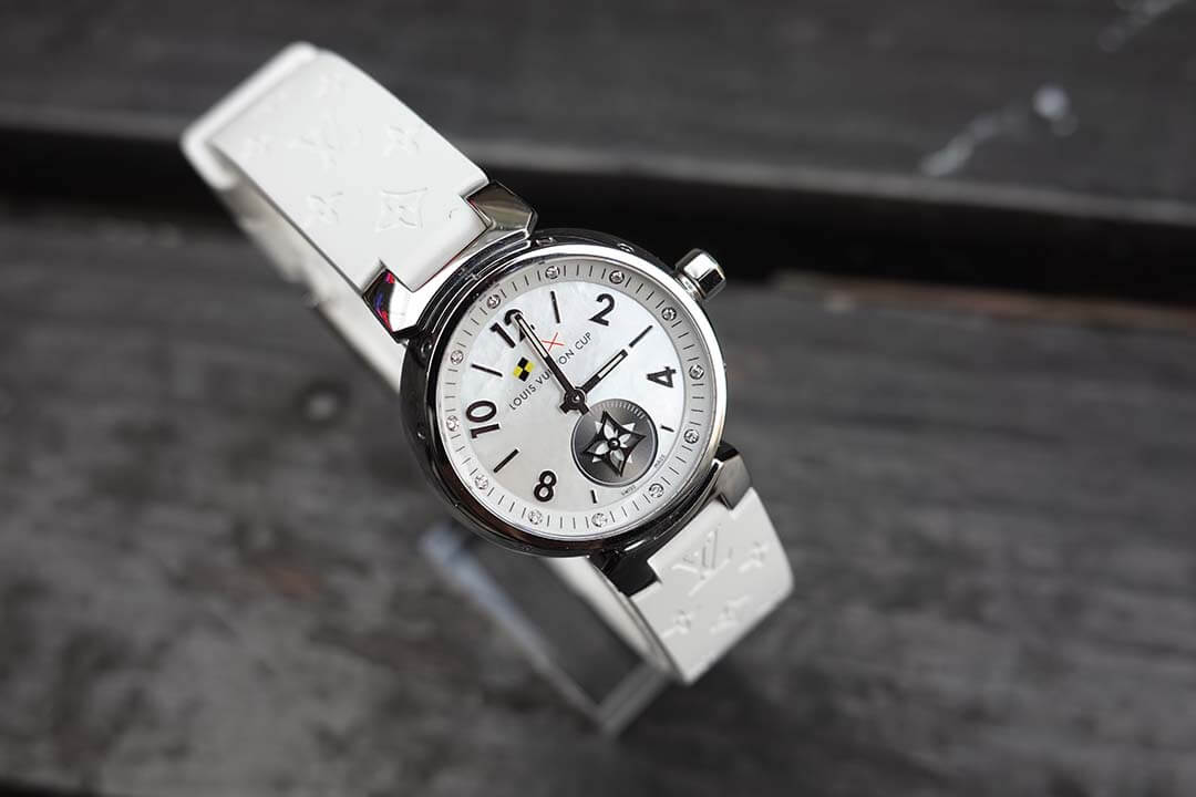 LV Cup 特別款女性腕錶,展示於黑色木桌上,搭配經典 LV 圖樣錶帶